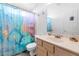 Bathroom featuring blue shower curtain, sink with beige cabinets and a white toilet at 16224 S 40Th Pl, Phoenix, AZ 85048
