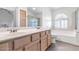 Bright bathroom with a double sink vanity, bathtub, and shower with glass door at 16224 S 40Th Pl, Phoenix, AZ 85048