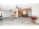 Open-concept living room with wood beam, ceiling fans, gray wood floors, and kitchen view at 16224 S 40Th Pl, Phoenix, AZ 85048