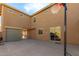 Spacious backyard featuring a basketball hoop, a covered patio, a two-car garage, and seamless indoor-outdoor living at 16510 W Tether Trl, Surprise, AZ 85387