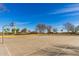 Outdoor community basketball court with hoops, a concrete surface, and surrounding shade trees at 16510 W Tether Trl, Surprise, AZ 85387