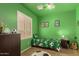 This cheerful bedroom features bright green walls, a ceiling fan, and a cozy twin bed with soccer-themed bedding at 16510 W Tether Trl, Surprise, AZ 85387