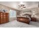 Main bedroom with carpet flooring, ceiling fan, and window with shutter at 16510 W Tether Trl, Surprise, AZ 85387