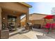 Relaxing covered patio area with outdoor furniture, barbecue grill, and charming red swing at 16510 W Tether Trl, Surprise, AZ 85387