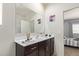 Stylish bathroom with a dark wood vanity, white countertop, and decorative accents at 18658 N Desert Willow Dr, Maricopa, AZ 85138
