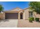 Inviting single-story home with a two-car garage, neutral stucco, and neat landscaping at 18658 N Desert Willow Dr, Maricopa, AZ 85138