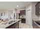 Bright, modern kitchen with stainless steel appliances, and granite countertops with dark cabinetry at 18658 N Desert Willow Dr, Maricopa, AZ 85138