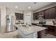 Modern kitchen features stainless steel appliances, granite countertops, and ample dark wood cabinetry at 18658 N Desert Willow Dr, Maricopa, AZ 85138