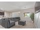 Inviting living area featuring an oversized gray sofa, large window, and stylish furnishings at 18658 N Desert Willow Dr, Maricopa, AZ 85138