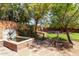 Landscaped backyard with stone water feature, mature trees, and a pathway to a fire pit at 18813 N 37Th Pl, Phoenix, AZ 85050