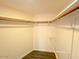 Bright walk-in closet with wooden clothes rods and white painted walls at 2121 W Union Hills Dr # 104, Phoenix, AZ 85027