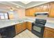 Well-lit kitchen featuring granite countertops, wooden cabinets, and modern black appliances at 2121 W Union Hills Dr # 104, Phoenix, AZ 85027