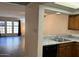 View of the open kitchen with white counters, a stainless sink, and a view of the living area at 2121 W Union Hills Dr # 104, Phoenix, AZ 85027