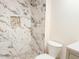 Beautifully tiled shower with white marble, a built in shelf, and stone tile floor at 2121 W Union Hills Dr # 104, Phoenix, AZ 85027