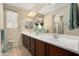 Bathroom with double sinks, a large mirror, and a separate shower area; decorated with fresh flowers at 21867 N 263Rd Dr, Buckeye, AZ 85396