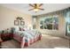 Cozy bedroom featuring a large window with backyard views, a ceiling fan, and neutral carpeting at 21867 N 263Rd Dr, Buckeye, AZ 85396