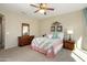 Bedroom featuring a large window, ceiling fan, neutral colored walls and carpet, and a comfy quilt at 21867 N 263Rd Dr, Buckeye, AZ 85396