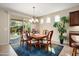 Charming dining area with a chandelier, wood table, and a sliding glass door to the backyard at 21867 N 263Rd Dr, Buckeye, AZ 85396