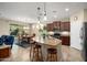 Well-lit kitchen featuring dark cabinetry, a stainless steel refrigerator, and an island with barstool seating at 21867 N 263Rd Dr, Buckeye, AZ 85396