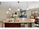 Kitchen island features a double sink, breakfast bar, and views to the living and dining areas at 21867 N 263Rd Dr, Buckeye, AZ 85396
