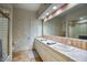 A bright bathroom with a double vanity, a large mirror, and tiled walls at 22500 N 97Th St, Scottsdale, AZ 85255