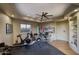 Exercise room with an attached work space, warm lighting, and hardwood flooring at 22500 N 97Th St, Scottsdale, AZ 85255