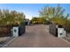 Long driveway featuring a private gate leading to a luxurious home with desert landscaping at 22500 N 97Th St, Scottsdale, AZ 85255