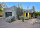 Exterior view of the house featuring the garage, desert landscaping, and stone accents at 22500 N 97Th St, Scottsdale, AZ 85255