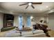 Spacious living room with fireplace, ceiling fan, and comfortable seating at 22500 N 97Th St, Scottsdale, AZ 85255