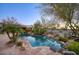 An inviting pool area with lush landscaping and a rock waterfall feature at 22500 N 97Th St, Scottsdale, AZ 85255