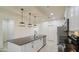Open kitchen with white cabinets, a large island with a sink, and modern pendant lighting at 23649 W Watkins St, Buckeye, AZ 85326