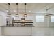 Bright kitchen with a central island, modern lighting, stainless-steel appliances, and tile flooring at 23649 W Watkins St, Buckeye, AZ 85326