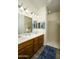 Bathroom featuring double sinks, wood cabinets, vanity mirrors, a shower, and a blue rug at 2663 S Springwood Blvd # 326, Mesa, AZ 85209