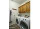 Laundry room with wood-look flooring, front loading washer and dryer, and overhead cabinets at 2663 S Springwood Blvd # 326, Mesa, AZ 85209