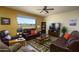 Cozy living room featuring a large window with views of the landscape, ceiling fan, and leather furnishings at 2663 S Springwood Blvd # 326, Mesa, AZ 85209
