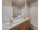 Bathroom featuring double sinks, a large mirror, and a separate tiled shower area at 2992 N Miller Rd # 103, Scottsdale, AZ 85251