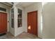 Covered entryway with orange door, sidelight window, and outdoor welcome mat at 2992 N Miller Rd # 103, Scottsdale, AZ 85251