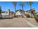 Gated community entrance featuring desert landscaping and palm trees under clear blue skies at 2992 N Miller Rd # 103, Scottsdale, AZ 85251