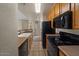 Functional kitchen equipped with essential appliances, breakfast bar, and tiled floors for easy maintenance at 2992 N Miller Rd # 103, Scottsdale, AZ 85251