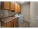 Well-lit laundry room includes washer, dryer, upper cabinets and countertop at 2992 N Miller Rd # 103, Scottsdale, AZ 85251