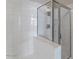 Shower stall featuring clear glass doors and white tiled walls at 2992 N Miller Rd # 103, Scottsdale, AZ 85251