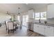 Eat-in kitchen with stainless appliances, white cabinets, subway tile backsplash, and sliding glass doors to the backyard at 3624 W Whitten St, Chandler, AZ 85226