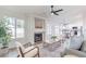 Open-concept living room with a fireplace, modern furniture, ceiling fan and easy access to the kitchen at 3624 W Whitten St, Chandler, AZ 85226