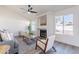 Bright living room with a fireplace, ceiling fan, modern furniture, and large windows at 3624 W Whitten St, Chandler, AZ 85226