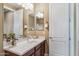 Bathroom vanity with wood cabinets, white countertop, modern fixtures, and a large mirror at 3713 E Cat Balue Dr, Phoenix, AZ 85050