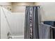 Bathroom shower with a silver shower head, faucet, and decorative patterned shower curtain at 3713 E Cat Balue Dr, Phoenix, AZ 85050
