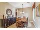 Formal dining room with wooden table, chandelier, built-in storage, decorative mirror and access to a wine cellar at 3713 E Cat Balue Dr, Phoenix, AZ 85050