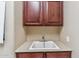 Convenient laundry room with a utility sink, cabinets, and ample counter space at 3713 E Cat Balue Dr, Phoenix, AZ 85050