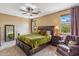 Spacious main bedroom featuring a ceiling fan, plush carpet, and natural light from the large windows at 3713 E Cat Balue Dr, Phoenix, AZ 85050