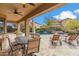 Covered patio with ceiling fan, outdoor dining table, and seating overlooking the sparkling swimming pool at 3713 E Cat Balue Dr, Phoenix, AZ 85050